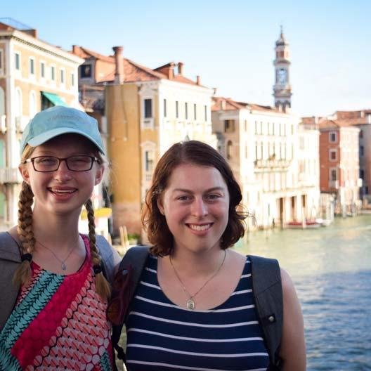 Two students smiling with a canal in Venice in the background